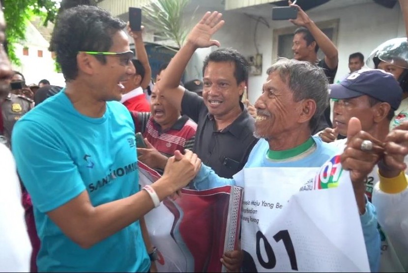 Calon wakil presiden (cawapres) Sandiaga Salahuddin Uno mengalungkan sorban kepada pendukung calon presiden nomor urut 01 Joko Widodo di Bojonegoro, Jumat (15/2).