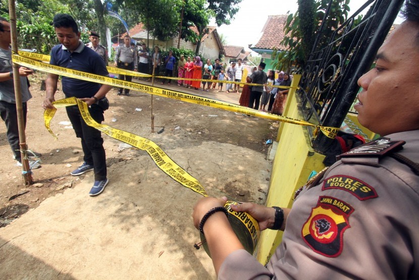 Polisi memasang garis polisi di lokasi terjadinya ledakan granat yang menyebabkan tiga anak menjadi korban di Desa Ciaruteun Ilir, Cibungbulang, Kabupaten Bogor, Jawa Barat, Jumat (15/2/2019).