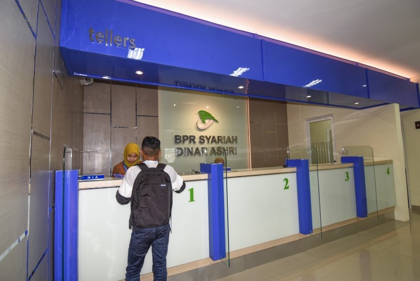 Seorang nasabah melakukan setoran tabungan Dinar Qurban di Bank Perkreditan Rakyat Syariah (BPRS) Dinar Ashri di Mataram, NTB, Jumat (15/2/2019).