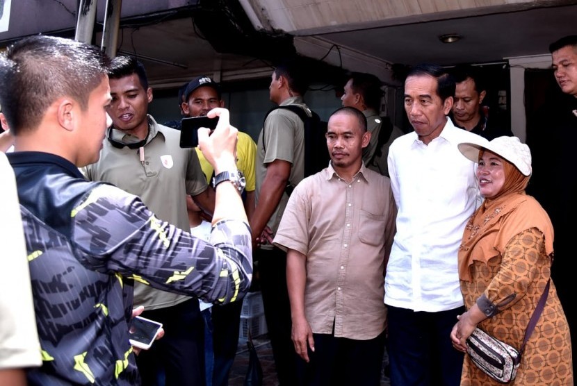 Calon presiden nomor urut 01, Jokowi, berfoto bersama warga usai menyantap hidangan makan siang bersama keluarganya di Kelapa Gading, Jakarta Utara, Ahad (17/2) siang. 