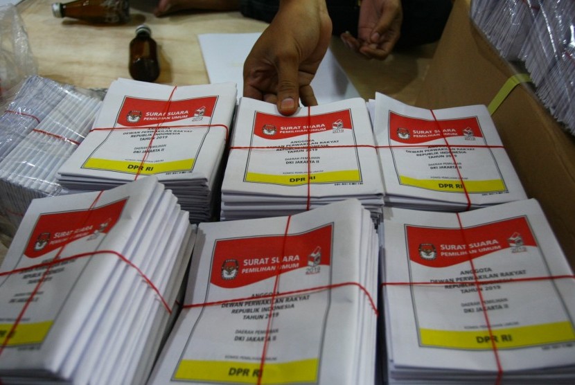Petugas logistik KPU Pusat melipat surat suara pemilihan Anggota DPR RI Pemilu 2019 untuk pemilih luar negeri di gudang logistik KPU di Benda, Tangerang, Banten, Ahad (17/2/2019). 