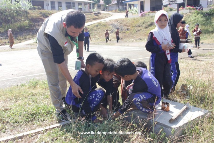 Anak-anak sekolah dasar di Aceh Besar bersama LKC Dompet Dhuafa membersihkan tempat yang bisa dijadikan sarang nyamuk penyebab DBD. 