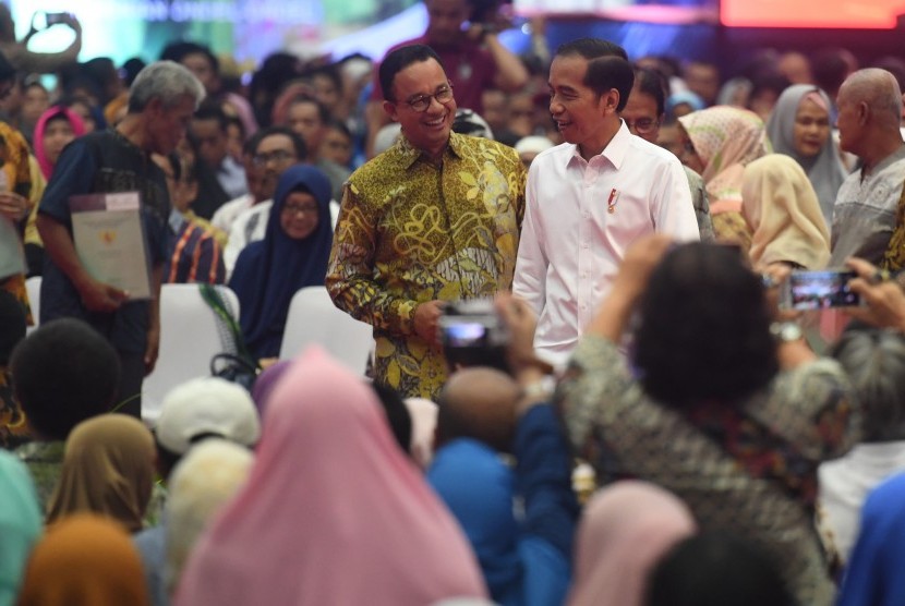 Jokowi Bagi Sertifikat: Presiden Joko Widodo kanan) berbincang dengan Gubernur DKI Jakarta Anies Baswedan (kiri) disela acara Penyerahan sertifikat tanah untuk rakyat di Gelanggang Remaja Pasar Minggu, Jakarta, Jumat (22/2/2019).