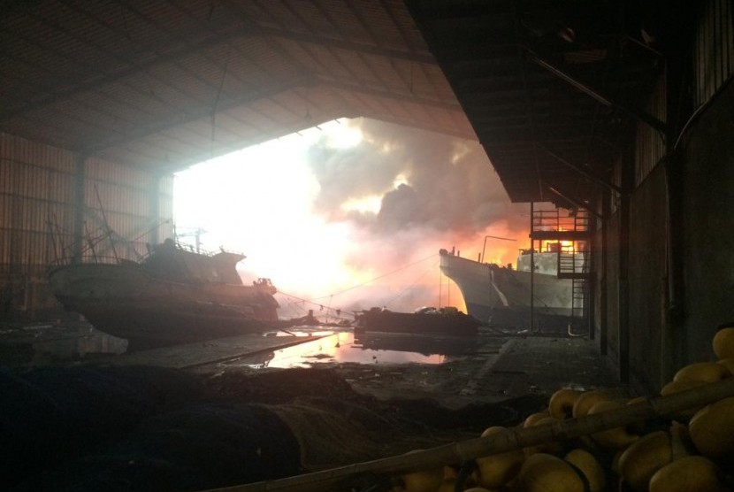 Kapal Ikan Terbakar: Api masih terus berkobar di Pelabuhan Muara Baru, Jakarta Utara, Sabtu (23/2). Garis polisi sudah dipasang di lokasi kejadian agar masyarakat tak nekat mendekat ke sumber kebakaran. 