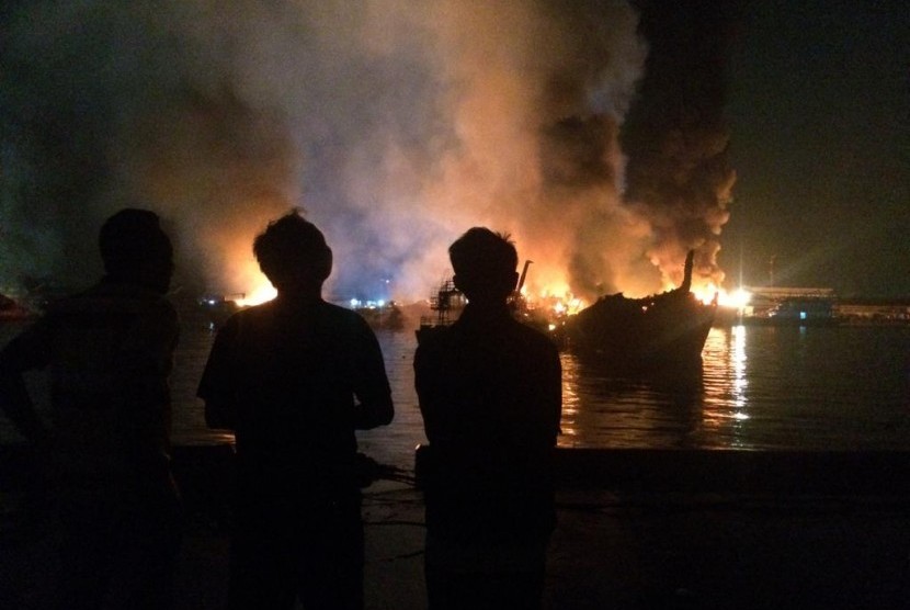 Kebakaran Kapal: Warga melihat sisa-sisa kapal yang terbakar di Pelabuhan Muara Baru, Jakarta Utara, Sabtu (23/2) malam.