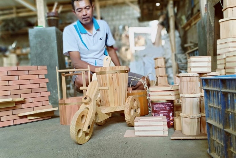 Produk Kerajinan Kayu: Agus Suherman (47) tengah menunjukan produk kerajinan yang dibuatnya di  bengkelnya di Lembang, Kabupaten Bandung Barat, Senin (25/2).
