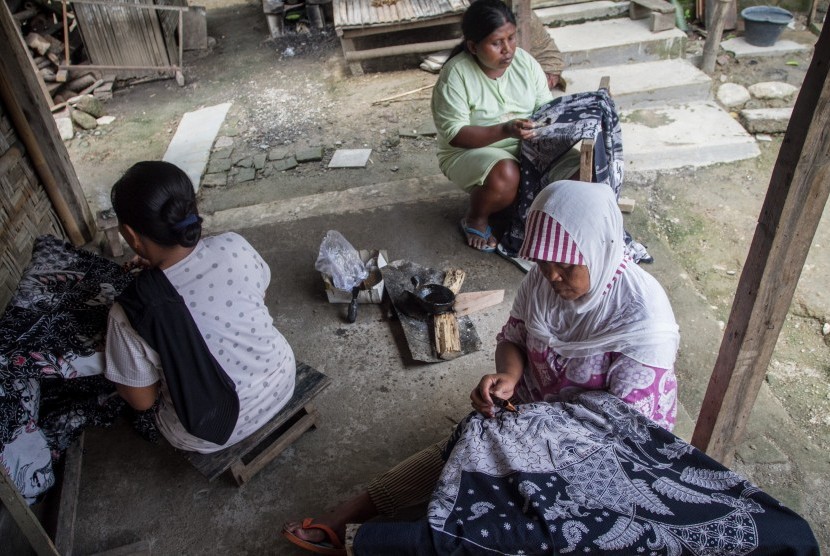 Buruh pembatik menyelesaikan proses pembuatan batik tulis 