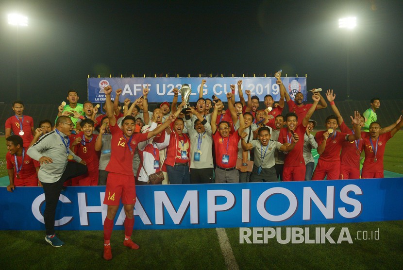 Pelatih Timnas U-22 Indra Sjafri (kedelapan kiri) bersama Menteri Pemuda dan Olah Raga Imam Nahrawi (ketujuh kiri) memegang piala beserta pemain dan Ofisial Timnas Indonesia seusai penganugerahan Piala AFF U-22 2019 di Stadion Nasional Olimpiade Phnom Penh, Kamboja, Selasa (26/2/2019).