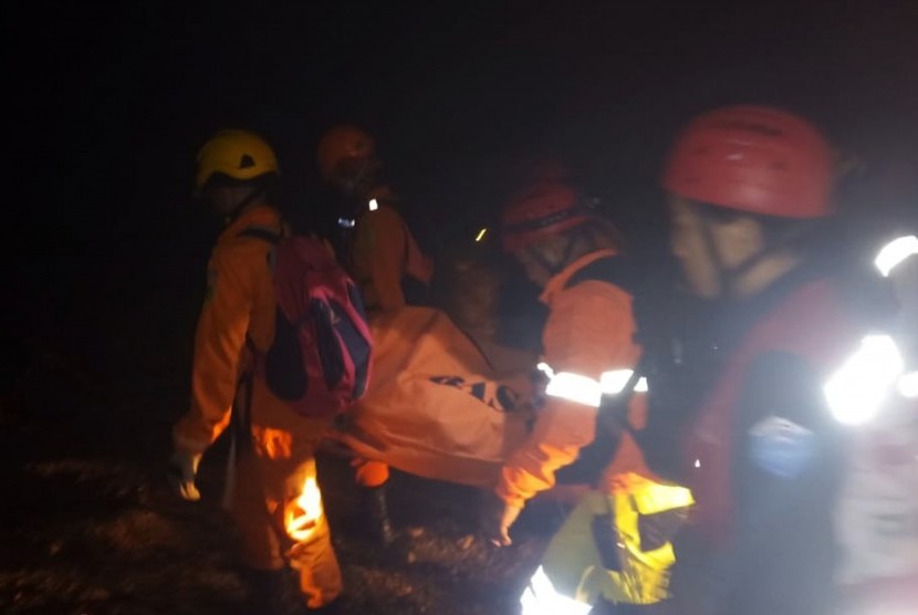 Sejumlah anggota tim SAR mengevakuasi salah seorang korban tambang emas yang longsor di Desa Bakan, Kecamatan Lolayan, Kabupaten Bolaang Mongondow, Sulawesi Utara, Selasa (26/2/2019) malam.