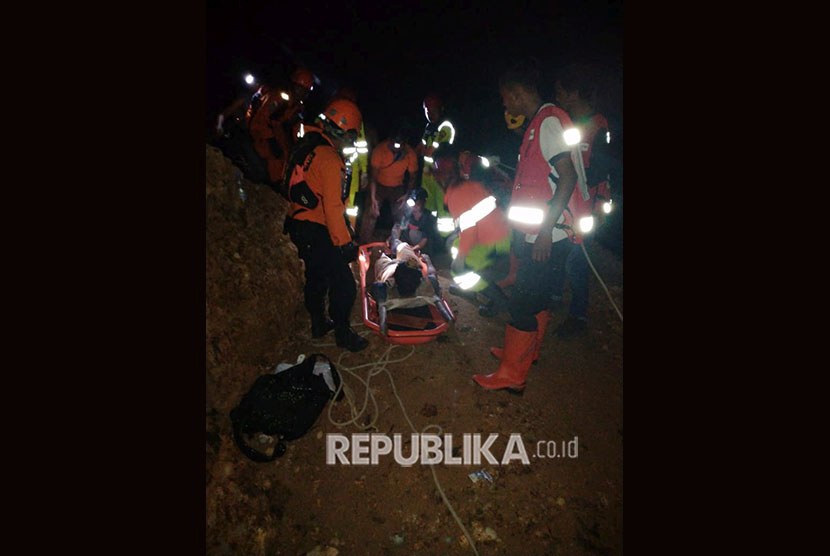 Sejumlah anggota tim SAR mengevakuasi salah seorang korban tambang emas yang longsor di Desa Bakan, Kecamatan Lolayan, Kabupaten Bolaang Mongondow, Sulawesi Utara, Selasa (26/2/2019) malam. 