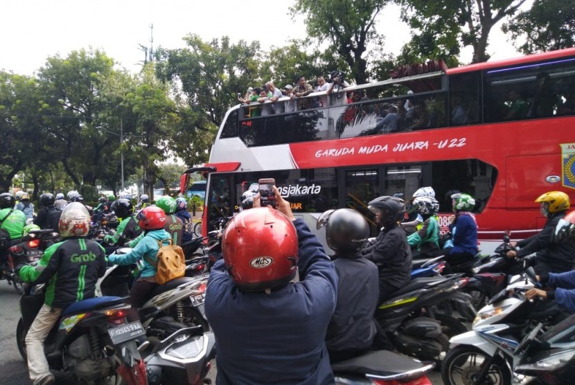 Pekerja dan pengguna jalan di jalan Thamrin menyaksikan pawai kemenangan Timnas sepakbola Indonesia U-22, Kamis (28/2). 