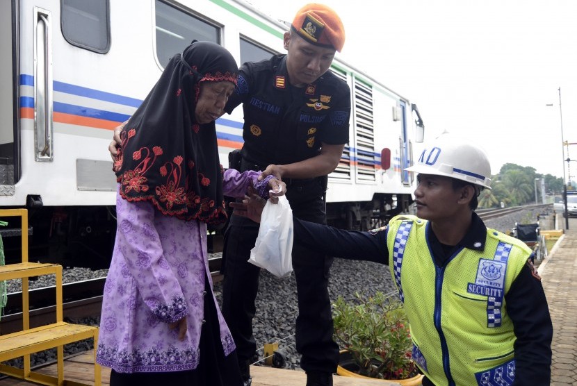 Petugas membantu warga melakukan pemeriksaan kesehatan di sebuah stasiun di Lampung (ilustrasi).