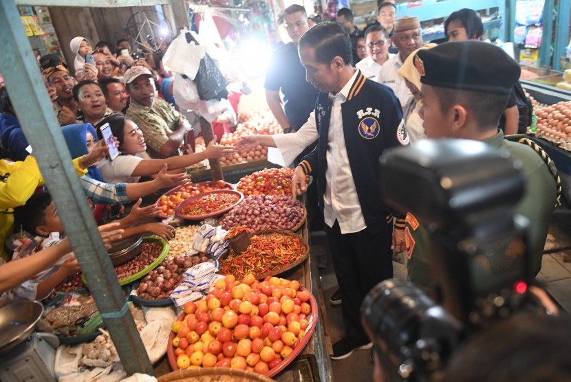 Jokowi Bantuan Ultra Mikro: Presiden Joko Widodo (kanan) menyapa warga sebelum menghadiri acara penyaluran bantuan pembiayaan ultra mikro di Pasar Sentral, Gorontalo, Jumat (1/3/2019).