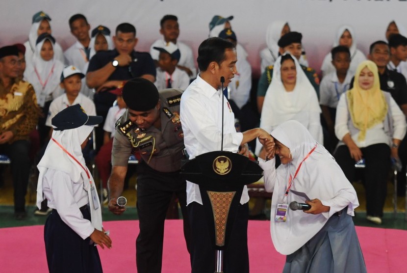 Jokowi Penyaluran KIP: Presiden Joko Widodo (kedua kanan) berjabat tangan dengan siswa saat penyerahan Kartu Indonesia Pintar (KIP) di Gorontalo, Jumat (1/3/2019).