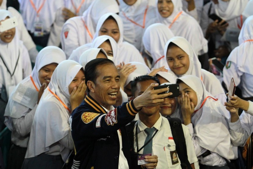 Jokowi Penyaluran KIP: Presiden Joko Widodo berswafoto bersama pelajar usai penyerahan Kartu Indonesia Pintar (KIP) di GOR David Tonny, Kabupaten Gorontalo, Gorontalo, Jumat (1/3/2019).
