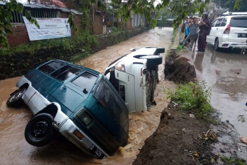 TPT Jebol: Dua unit mobil yang terparkir di pinggir sungai Sasak Dua, Ciapus,  Kecamatan Banjaran, Kabupaten Bandung terguling masuk ke dalam aliran air  tersebut sekitar pukul 16.38 Wib, Jumat (1/3).