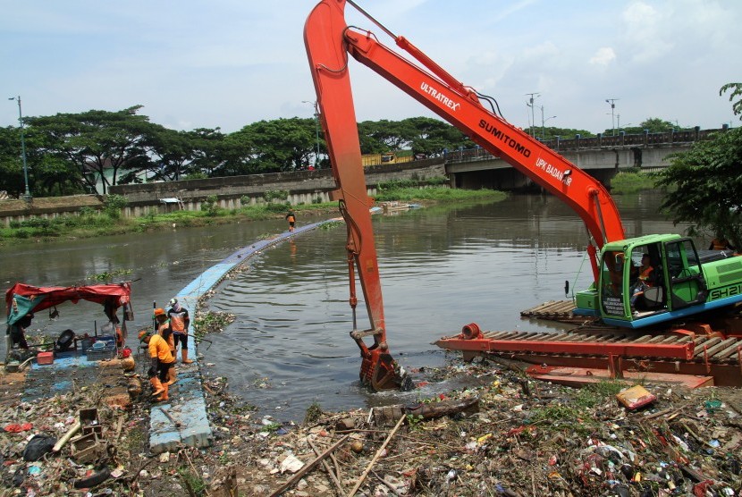Petugas Dinas Kebersihan mengoperasikan alat berat untuk mengangkut tumpukan sampah di aliran air Kanal Banjir Timur (KBT) kawasan Marunda, Jakarta, Selasa (5/3/2019). 