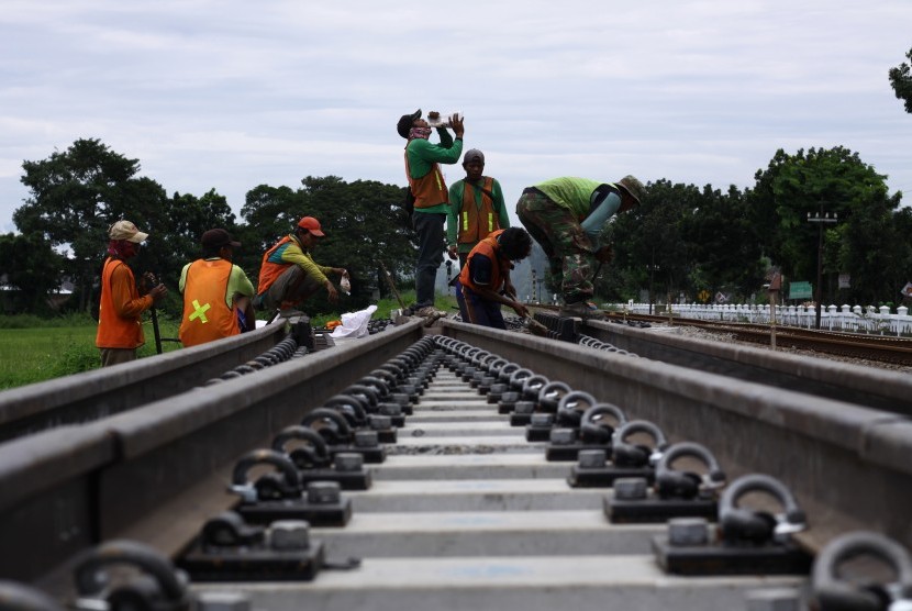 Pekerja memasang rel proyek jalur ganda rute Jombang-Madiun yang melintas di Desa Pandanwangi, Kecamatan Diwek, Kabupaten Jombang, Jawa Timur.