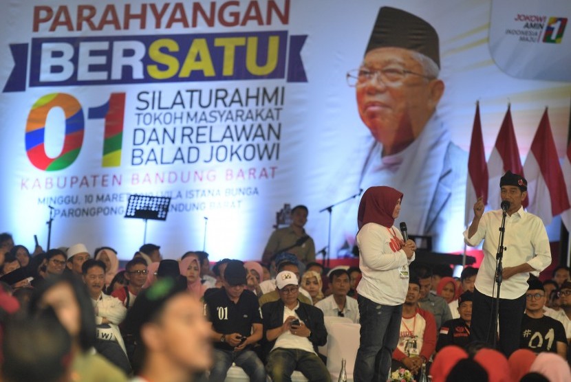 Calon Presiden Joko Widodo (kanan) berdialog dengan relawan dalam acara Parahyangan Bersatu yang juga menjadi ajang silaturahmi dengan tokoh masyarakat dan relawan Balad Jokowi di Aula Villa Istana Bunga, Bandung Barat, Jawa Barat, Ahad (10/3/2019).