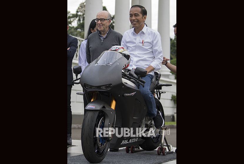 Presiden Joko Widodo (kanan) didampingi CEO Dorna Carmelo Ezpeleta (kiri) mencoba motor balap di Istana Bogor, Jawa Barat, Senin (11/3/2019).