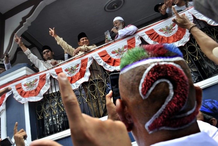 Calon Presiden nomor urut 02 Prabowo Subianto (tengah) bersama sesepuh Ponpes Cidahu KH Abuya Murtadho (kanan) menyapa pendukungnya di Kampung Cidahu, Pandeglang, Banten, Sabtu (16/3/2019). 