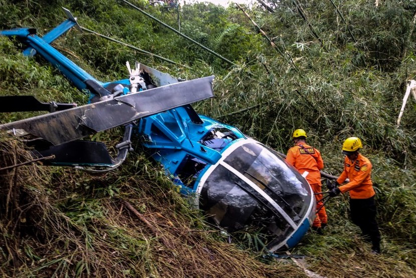 Petugas Basarnas memeriksa helikopter B-105 PK EAH milik PT Air Transport Service yang jatuh di Desa Jayaratu, Kabupaten Tasikmalaya, Jawa Barat, Sabtu (16/3/2019). 