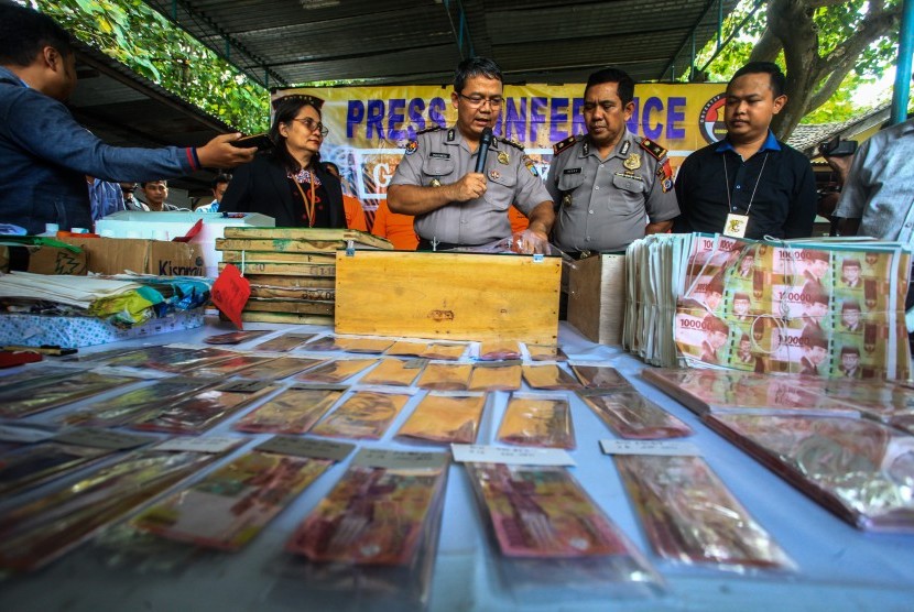 Polisi menunjukkan barang bukti uang palsu hasil sitaan saat jumpa pers di Polsek Godean, Sleman, DI Yogyakarta, Selasa (19/3/2019).