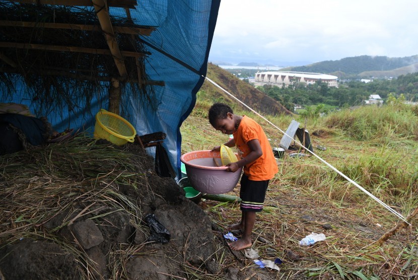 Seorang anak pengungsi banjir bandang Sentani merapikan perabotan ke dalam tenda darurat yang mereka dirikan di Bukit Harapan, Sentani, Jaya Pura, Papua, Rabu (20/3/2019).