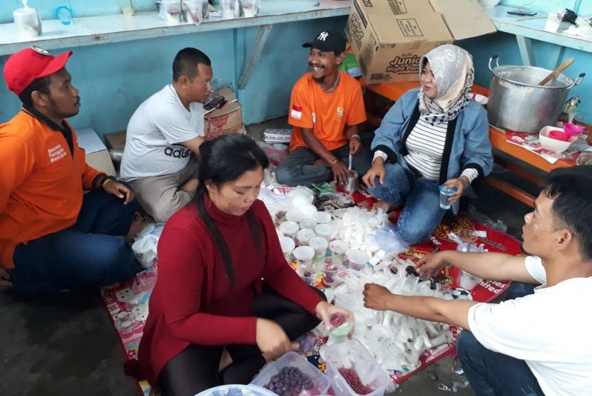 Relawan Baznas dan Rina Yulyana menyiapkan sarapan pagi bubur sumsum untuk para warga yang terdampak bencana banjir bandang di Sentani, Jayapura, Papua, Kamis (21/3). 