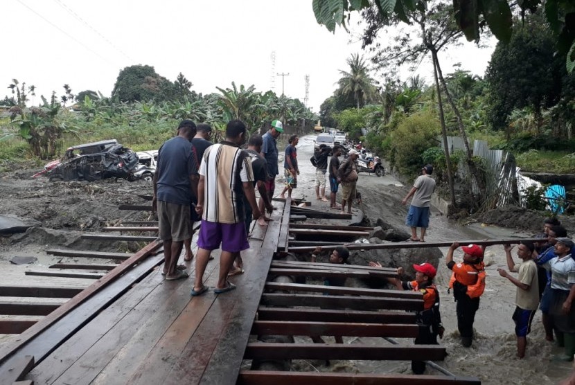 Relawan Baznas Tanggap Bencana dan warga Sentani bergotong-royong membangun jembatan darurat di Kelurahan Hinekombe, Sentani, Jayapura, Papua, Kamis (21/3). 