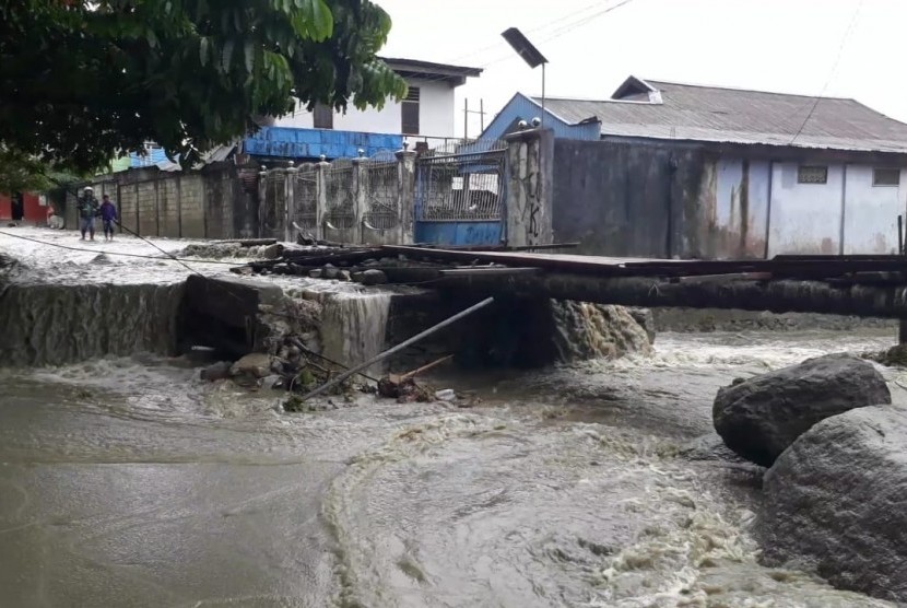 Jembatan ambrol akibat banjir bandang di Hinekombe, Sentani, Jayapura, Papua, Kamis (21/3). Warga kemudian bersama Baznas membangun jembatan darurat dengan menggunakan bahan kayu.