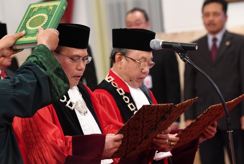 Hakim Konstitusi Aswanto (kiri) dan Wahiduddin Adams mengucapkan sumpah di hadapan Presiden Joko Widodo di Istana Negara, Jakarta, Kamis (21/3/2019).