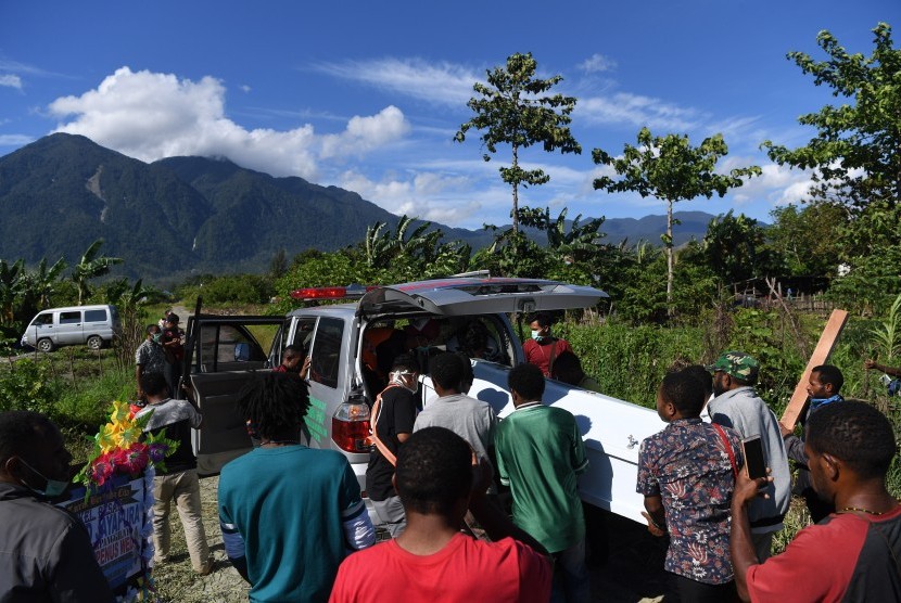 Keluarga duka mengangkat peti yang berisi jenazah korban banjir bandang Sentani ke dalam mobil jenazah untuk dimakamkan di Sentani, Jayapura, Papua, Sabtu (23/32019). 