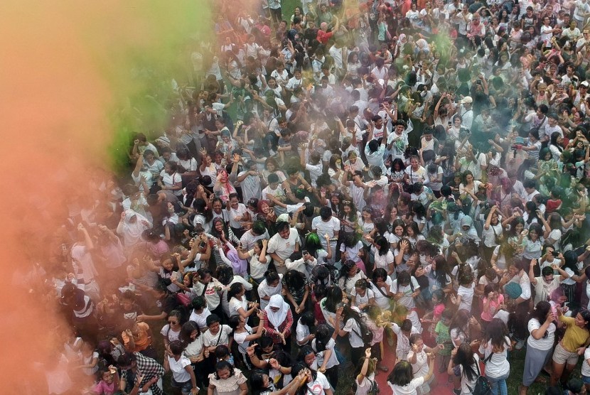 Sejumlah warga dan wisatawan saling melemparkan bubuk warna-warni saat Festival Holi di Denpasar, Bali, Sabtu (23/3/2019).