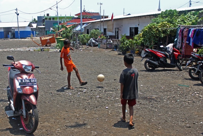 Anak-anak bermain di lapangan dekat shelter atau hunian sementara di Kampung Akuarium, Jakarta, Selasa (26/3/2019). 