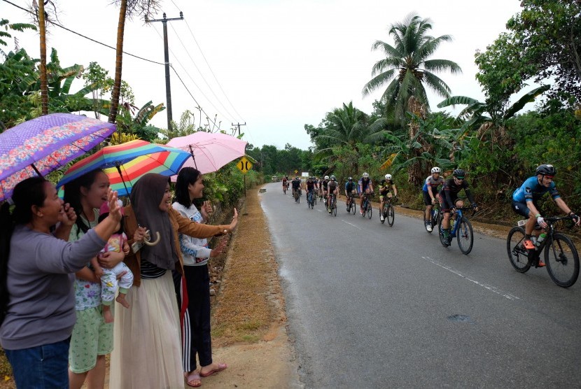 Penonton memberi semangat kepada Pebalap saat mengikuti Tour de Bintan 2019 di Kabupaten Bintan Provinsi Kepri, Sabtu (30/3/2019). Pemerintah Kabupaten Bintan, Kepulauan Riau, menargetkan sebanyak 3.000 orang wisatawan mancanegara (wisman) mengunjungi daerah tersebut saat Tour de Bintan.