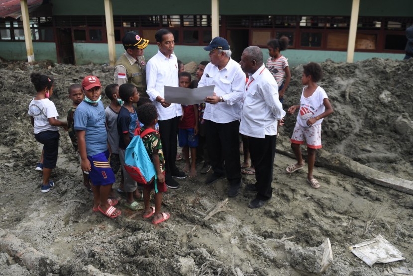 Presiden Joko Widodo (kedua kiri) berbincang dengan Menteri PUPR Basuki Hadimuljono (kedua kanan) dan Kepala BNPB Doni Monardo (kiri) saat mengunjungi area terdampak banjir bandang Sentani di Jayapura, Papua, Senin (1/4/2019).