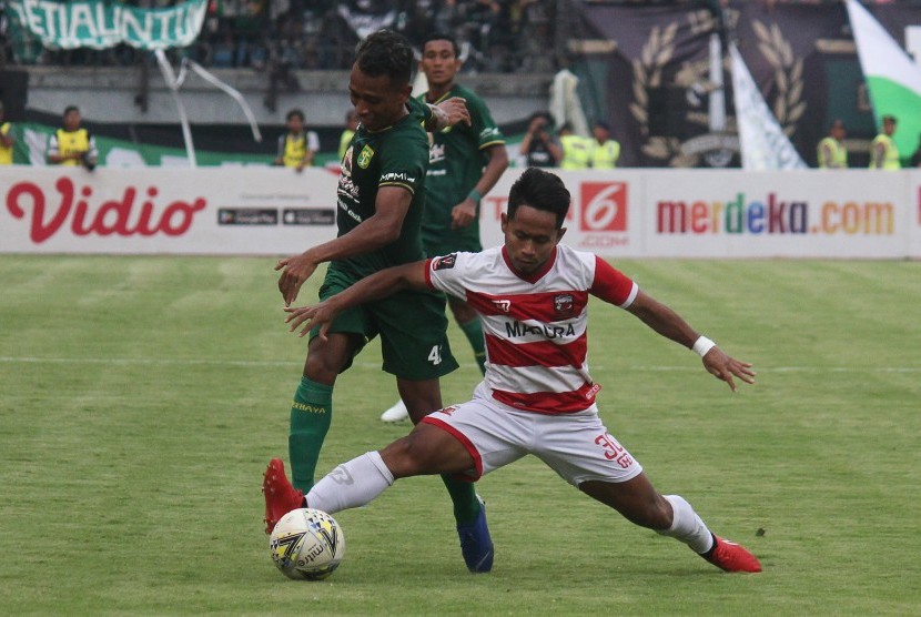Pesepak bola Persebaya Surabaya Irfan Jaya (kiri) mencoba melewati adangan pesepak bola Madura United Andik Vermansah (kanan) saat pertandingan semifinal Piala Presiden 2019 leg pertama di Stadion Gelora Bung Tomo, Surabaya, Jawa Timur, Rabu (3/4).