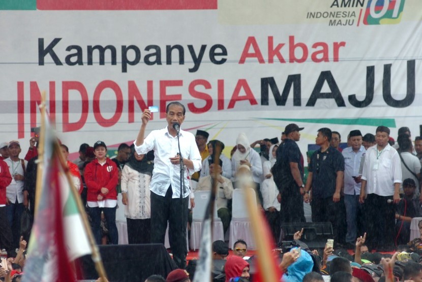 Calon Presiden nomor urut 01 Joko Widodo menunjukkan salahsatu kartu ketika kampanye terbuka di Lapangan Dukuhsalam, Kabupaten Tegal, Jawa Tengah, Kamis (4/4/2019). 