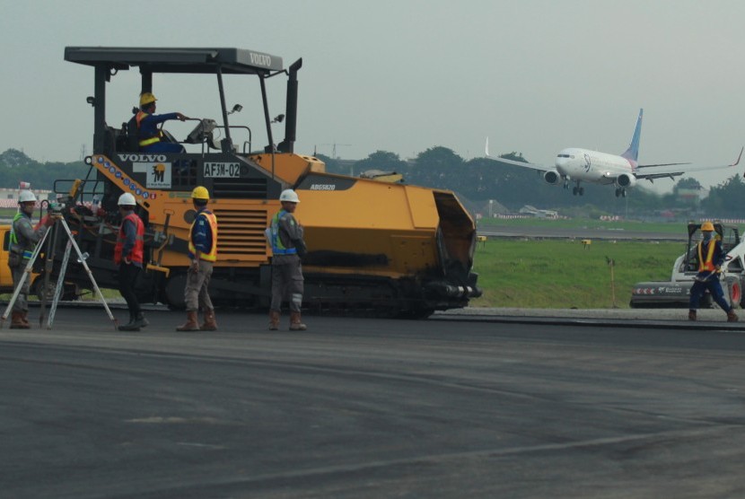 Pekerja melakukan pengaspalan proyek pembangunan Run Way 3 dan Eastcross Taxi Way Bandara Soekarno-Hatta, Tangerang, Banten, Jumat (5/4).