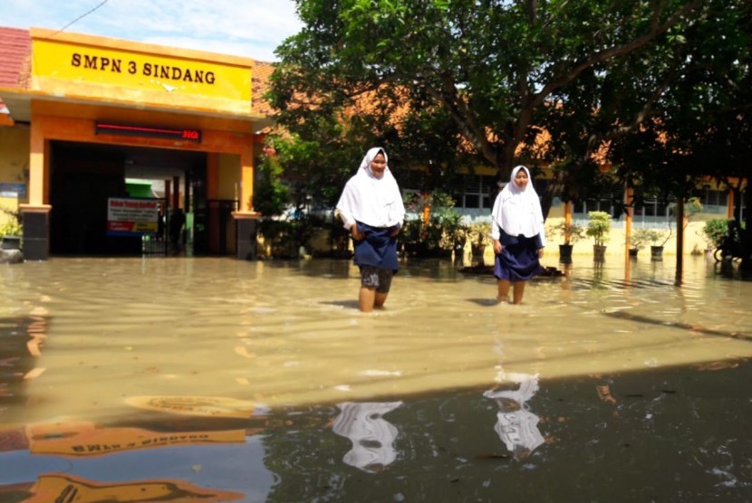 Para siswa SMPN 3 Sindang mengerjakan USBN dengan kondisi ruang kelas yang terendam banjir, Selasa (9/4). Memasuki hari kedua, banjir akibat luapan sungai Cimanuk di Kabupaten Indramayu semakin meluas.