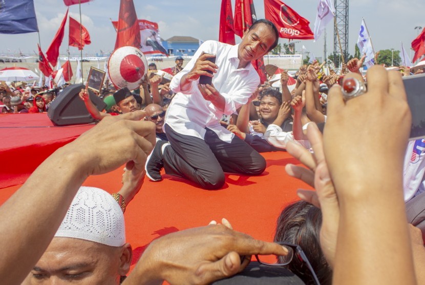 Calon Presiden nomor urut 01 Joko Widodo (tengah) berswafoto dengan pendukung saat kampanye akbar di Stadion Singaperbangsa, Karawang, Jawa Barat, Selasa (9/4/2019). 