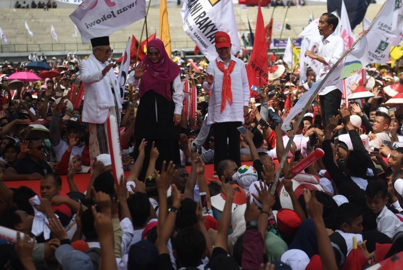 Calon Presiden dan Wakil Presiden nomor urut 01 Joko Widodo (kanan), Ma'ruf Amin (kiri) beserta Istri Iriana Joko Widodo (kedua kanan) dan Wury Estu Handayani (kedua kiri) menyapa pendukung saat kampanye di Karawang, Jawa Barat, Selasa (9/4/2019). 