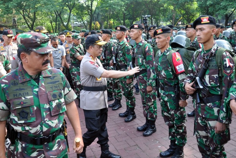 Panglima TNI Marsekal TNI Hadi Tjahjanto (kiri) bersama Kapolri Jenderal Pol Tito Karnavian (tengah) memeriksa pasukan pengamanan Pemilu 2019 di Medan, Sumatera Utara, Kamis (11/4/2019). 