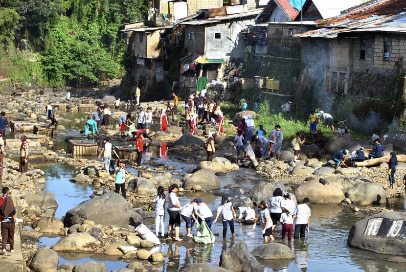 Anggota Pramuka Penegak Kota Bogor memungut sampah di aliran sungai Ciliwung, Kampung Pulogeulis, Kota Bogor, Jawa Barat, Jum