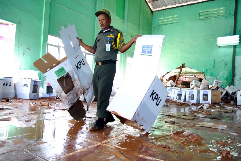 Petugas Hansip membawa kotak surat suara Pemilu 2019 yang rusak akibat terkena banjir di Gedung GOR Serbaguna, Ciseeng, Kabupaten Bogor, Jawa Barat, Senin (15/4/2019). 