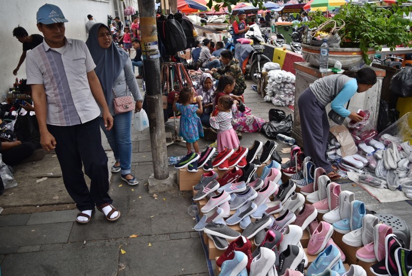 Warga berjalan di trotoar yang menjadi lokasi berjualan pedagang kaki lima (PKL) di kawasan Kota Tua, Jakarta Barat, Sabtu (20/4/2019).