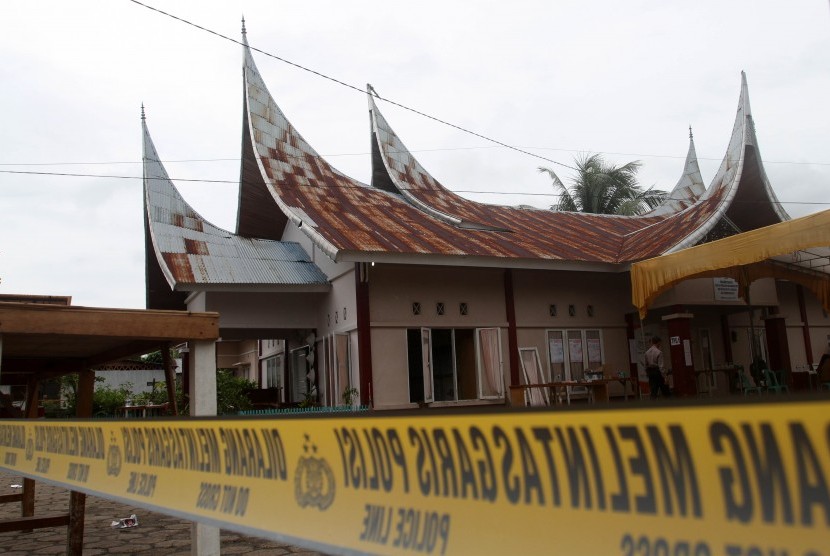 Polisi melintas di samping Sekretariat Panitia Pemilihan Kecamatan (PPK) yang terbakar di Nagari Kapuh, Kecamatan Koto XI, Kabupaten Pesisir Selatan, Sumatera Barat, Senin (22/4/2019). 
