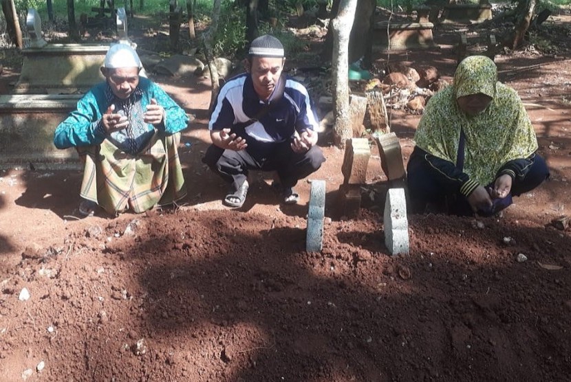 Sejumlah kerabat masih mendoakan almarhum Nasokha (55) di pemakaman, Selasa (23/4). Ketua KPPS di TPS 09 Desa Gondoriyo, Kecamatan Bergas, Kabupaten Semarang, meninggal dunia akibat kelelahan