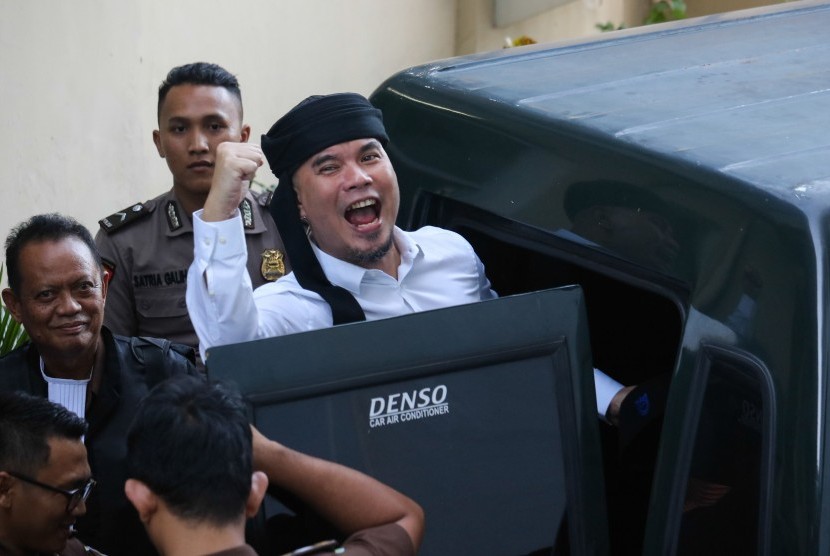 Terdakwa kasus dugaan pencemaran nama baik Ahmad Dhani Prasetyo (kanan) masuk ke mobil tahanan usai mengikuti sidang tuntutan di Pengadilan Negeri Surabaya, Jawa Timur, Selasa (23/4/2019). 